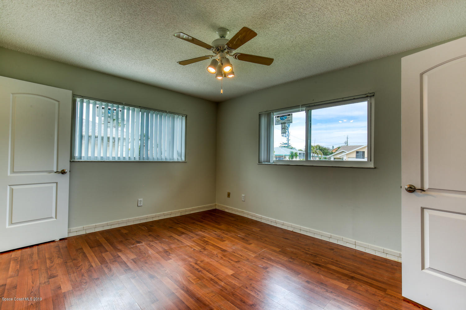 201 Ocean View Lane Melbourne, FL 32903 - Photo 12 of 21 an empty room with wooden floor chandelier and windows