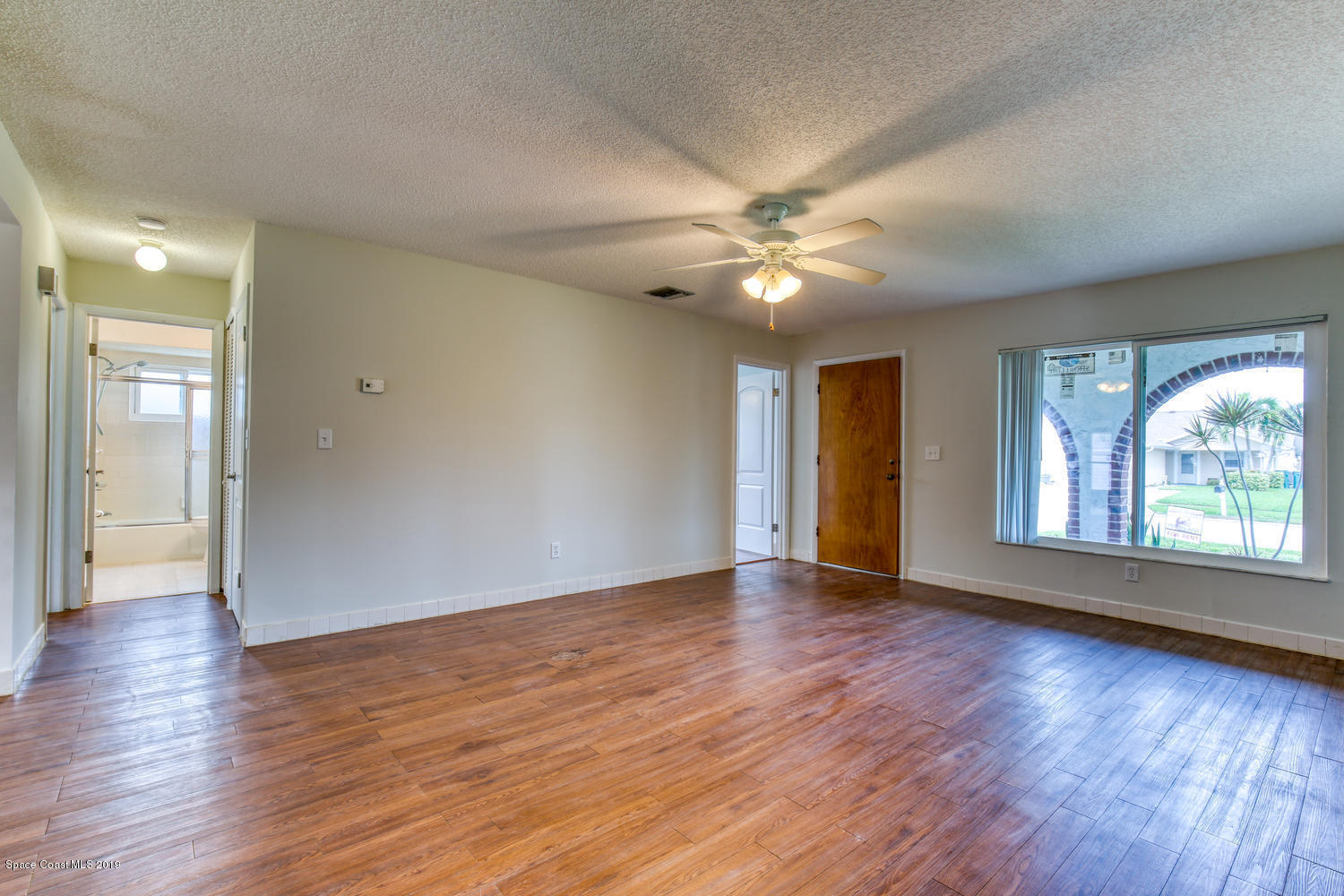 201 Ocean View Lane Melbourne, FL 32903 - Photo 5 of 21 a view of an empty room with window and wooden floor
