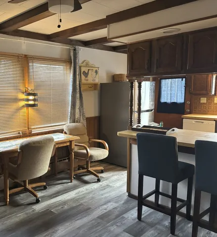 a view of a workspace with furniture and a window