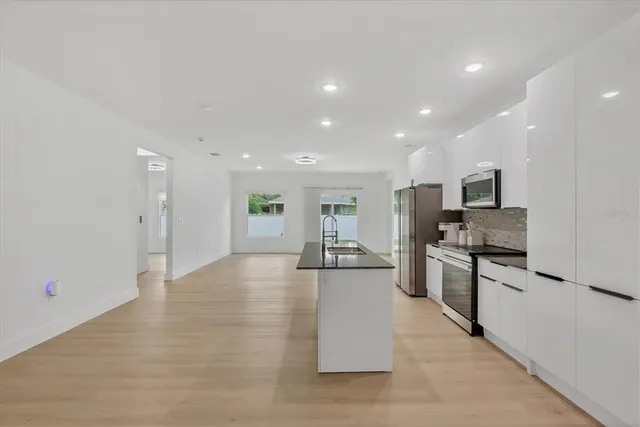 a view of kitchen with stainless steel appliances kitchen island sink stove and refrigerator