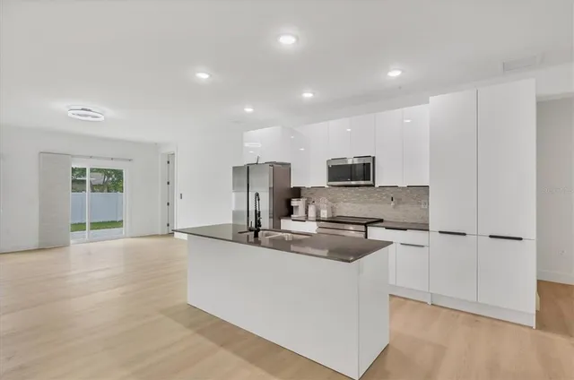 a kitchen with stainless steel appliances a refrigerator and a stove top oven