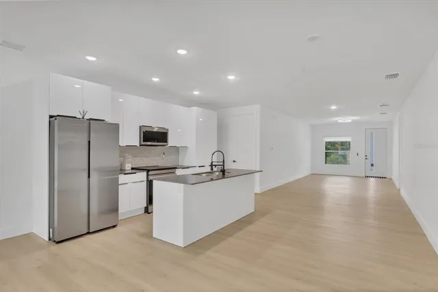 a kitchen with stainless steel appliances a refrigerator sink and stove