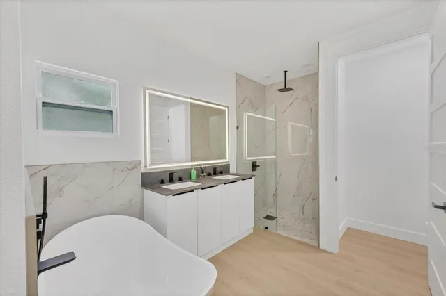 a bathroom with a tub a sink and mirror