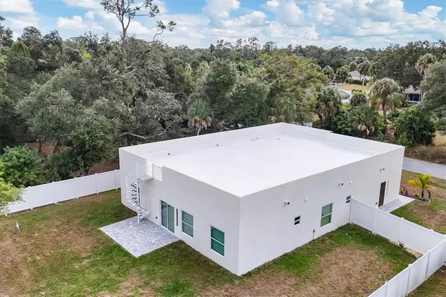 an aerial view of a house with swimming pool and outdoor seating