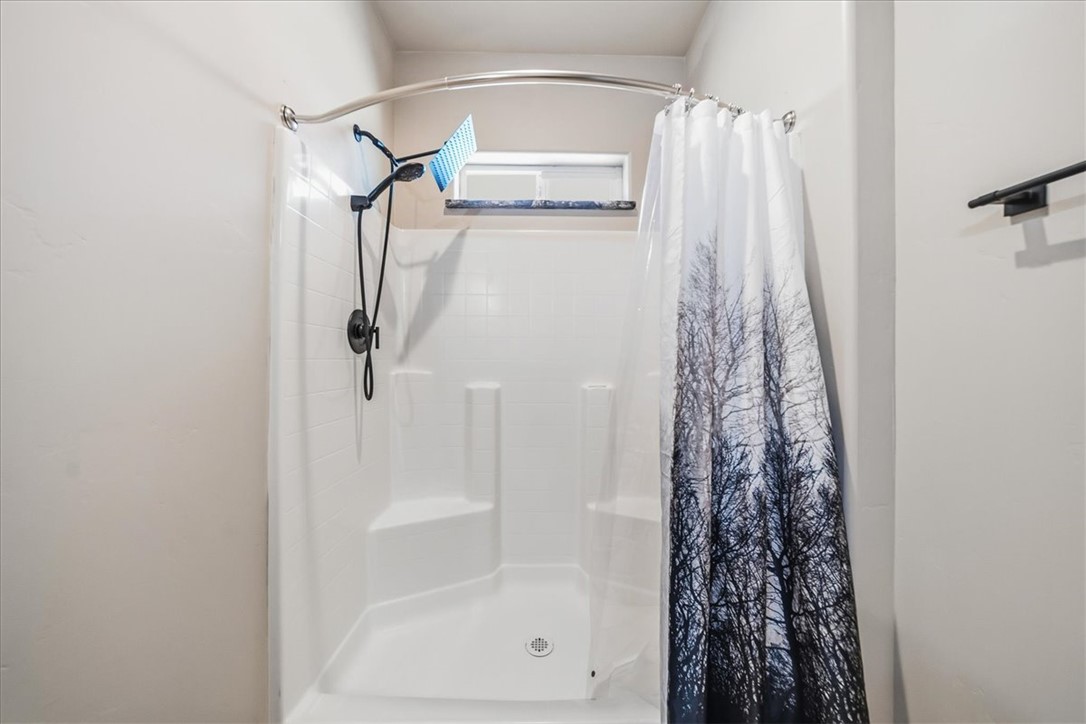 10374 East Happy Trails Road Kingman, AZ 86401 - Photo 37 of 68 a bathroom with a shower curtain and a window
