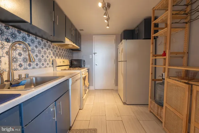 a view of storage and utility room with refrigerator washer and dryer