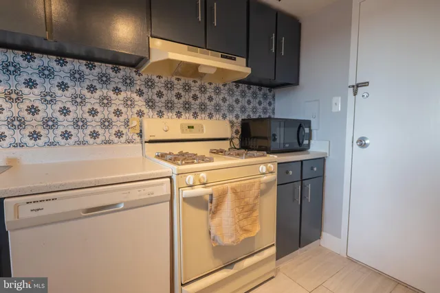 a kitchen with granite countertop a sink and a refrigerator