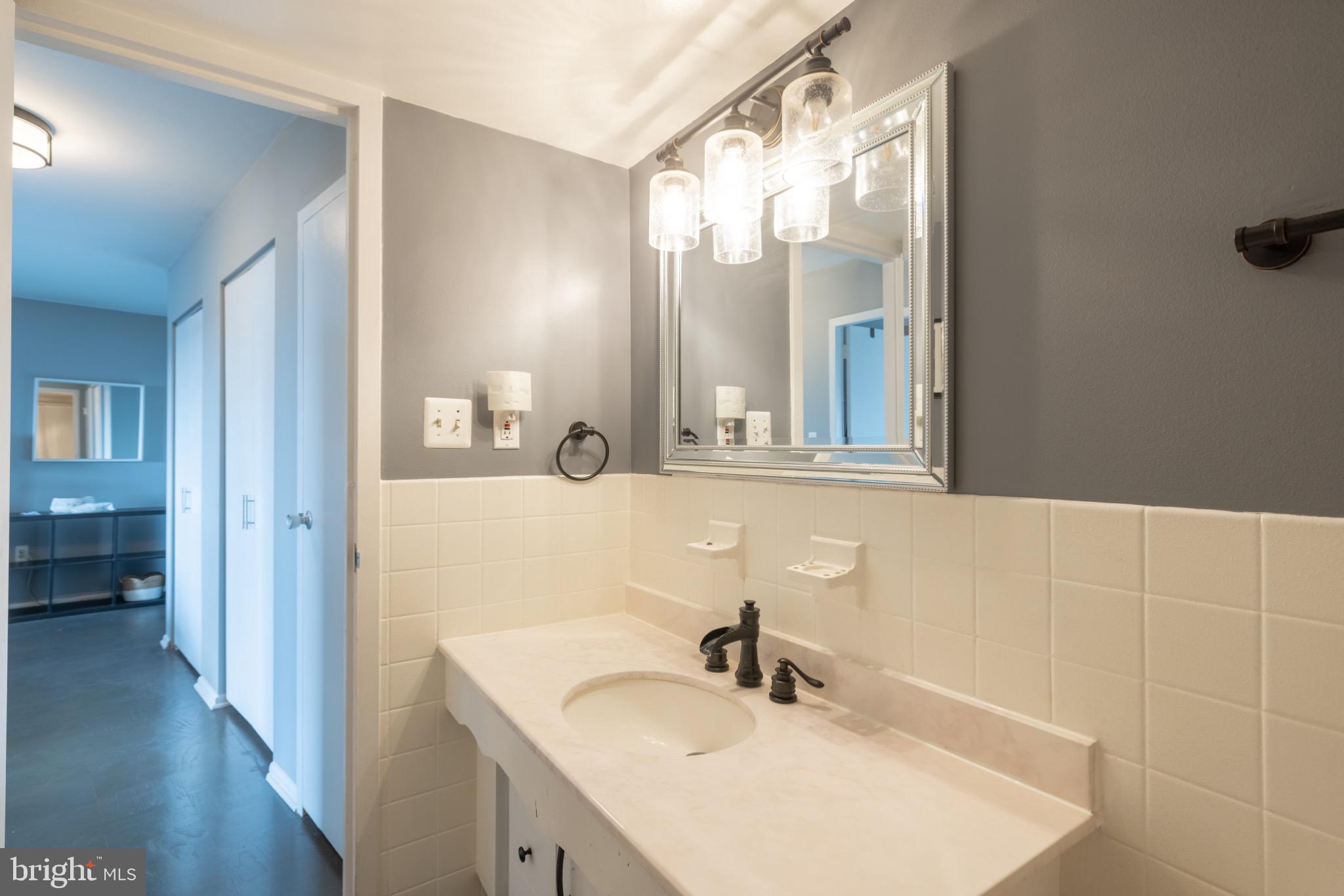 1111 University Boulevard West, Unit 1411A Silver Spring, MD 20902 - Photo 29 of 36 a bathroom with a sink and a mirror