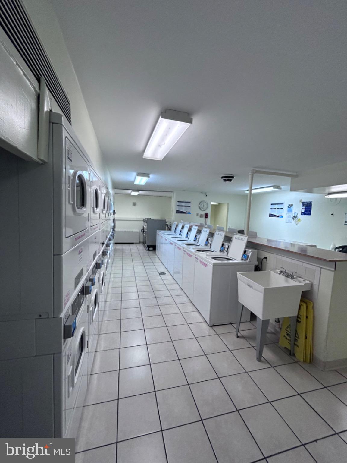 1111 University Boulevard West, Unit 1411A Silver Spring, MD 20902 - Photo 31 of 36 a room with kitchen island stainless steel appliances lots of counter space and windows