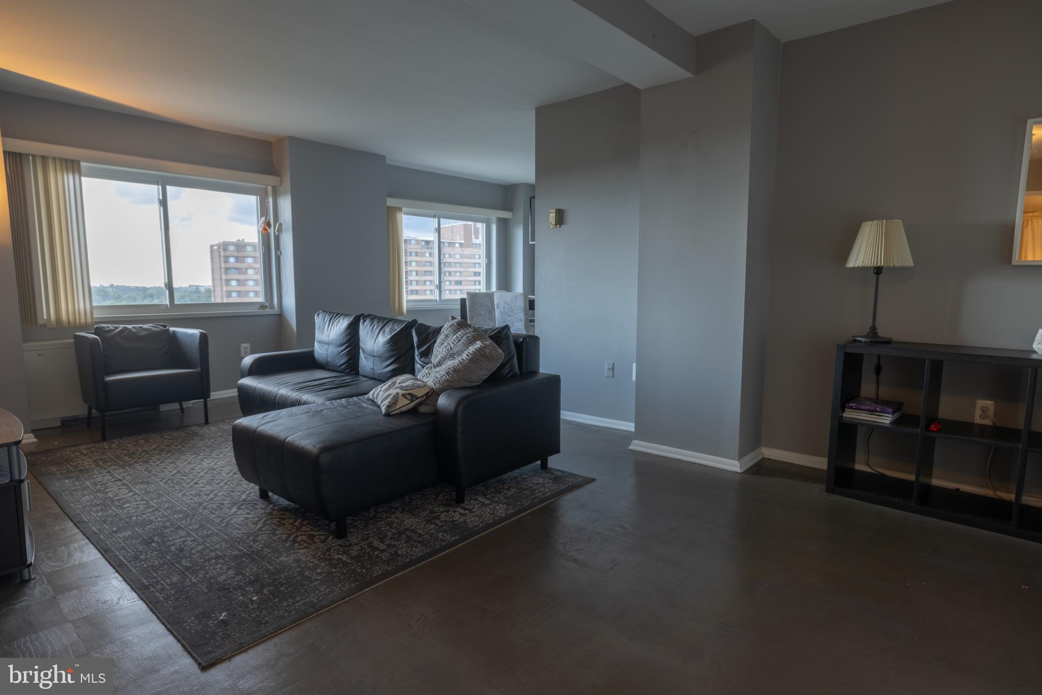 1111 University Boulevard West, Unit 1411A Silver Spring, MD 20902 - Photo 10 of 36 a living room with furniture and a window