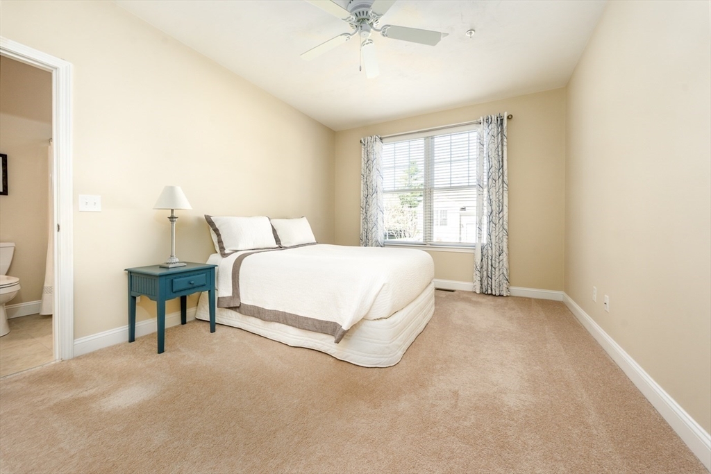 24 Grey Hawk Drive, Unit 646 Mashpee, MA 02649 - Photo 16 of 24 a spacious bedroom with a bed and a table