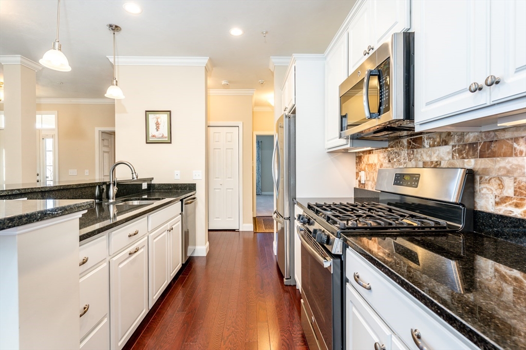 24 Grey Hawk Drive, Unit 646 Mashpee, MA 02649 - Photo 5 of 24 a kitchen with stainless steel appliances granite countertop a sink stove and refrigerator