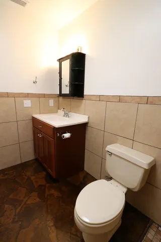 a bathroom with a toilet a sink and mirror