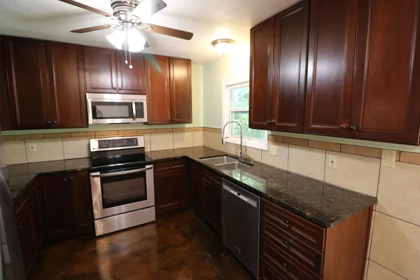 a kitchen with granite countertop stainless steel appliances and wooden cabinets