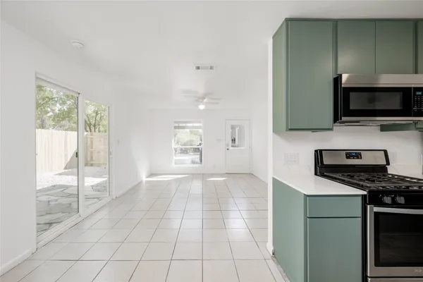 a kitchen with granite countertop a stove a sink and a microwave