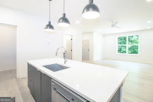 a kitchen with a sink a center island and a chandelier