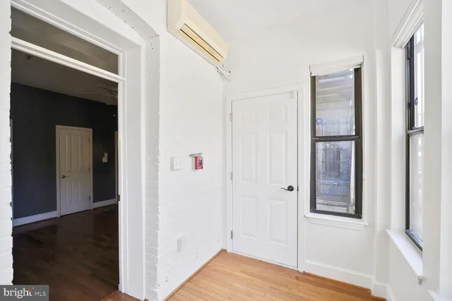 a view of a hallway with wooden floor and closet