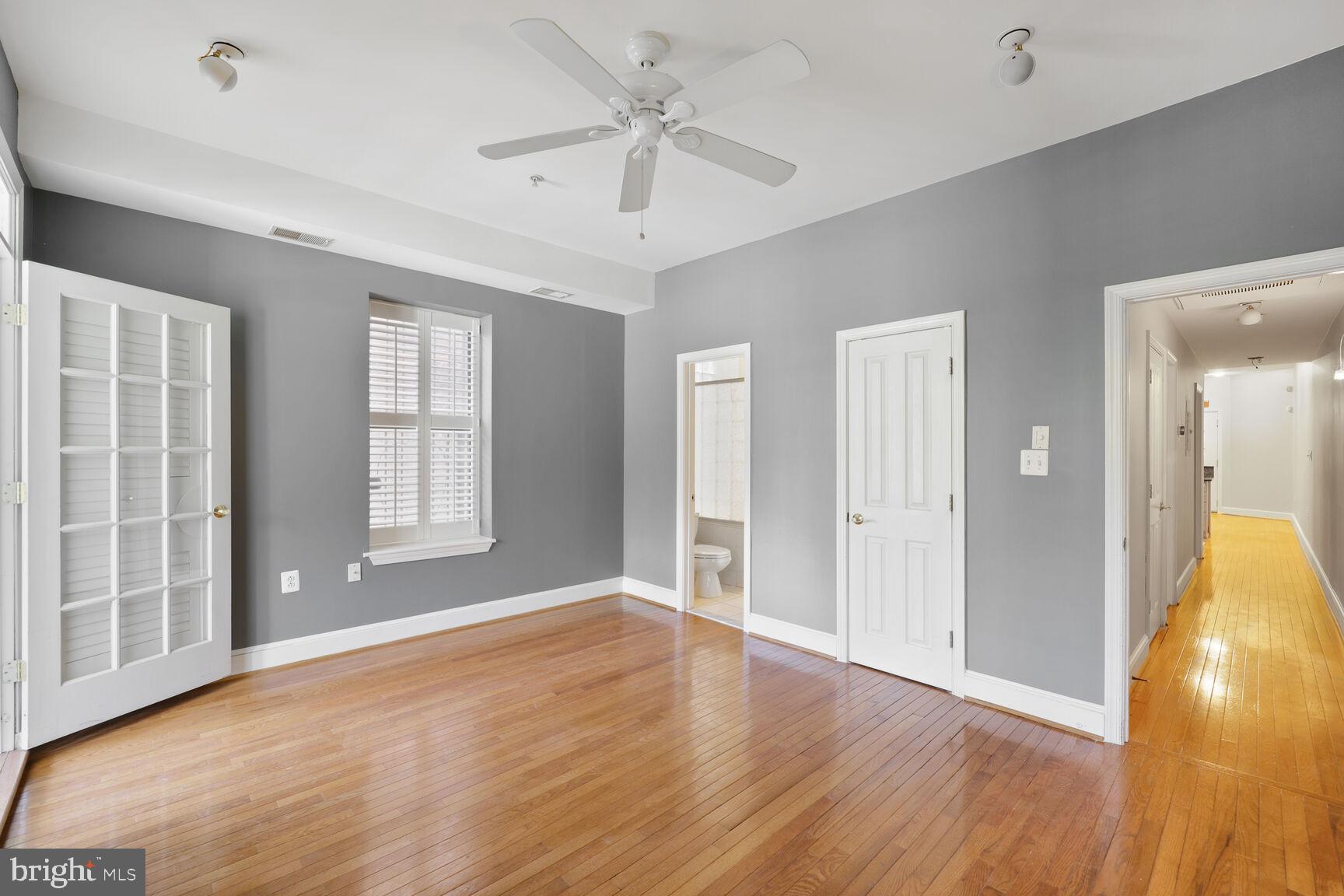 1419 Clifton Street Northwest, Unit 105 Washington, DC 20009 - Photo 13 of 19 a view of an empty room with window and wooden floor