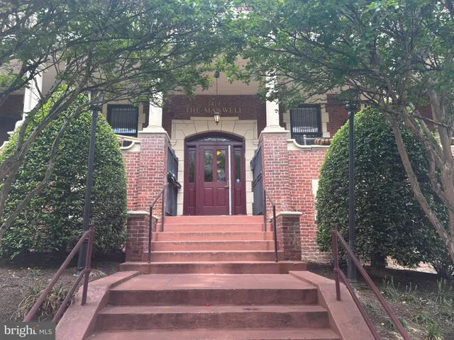 a front view of a house with a tree