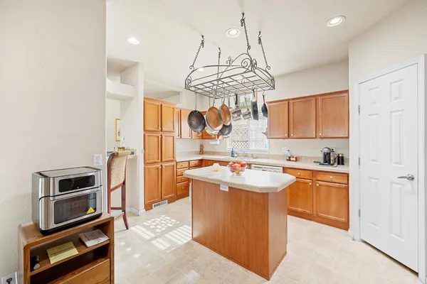 a kitchen with kitchen island stainless steel appliances a stove sink and refrigerator