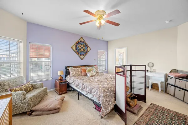 a bedroom with a bed a couch and a chandelier