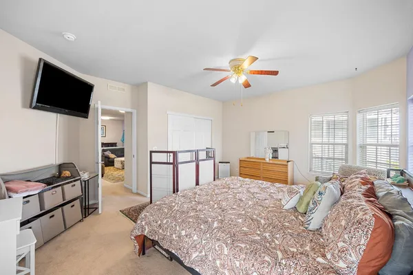 a bedroom with a bed a dresser and a flat screen tv