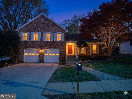 a front view of a house with a yard and a garden