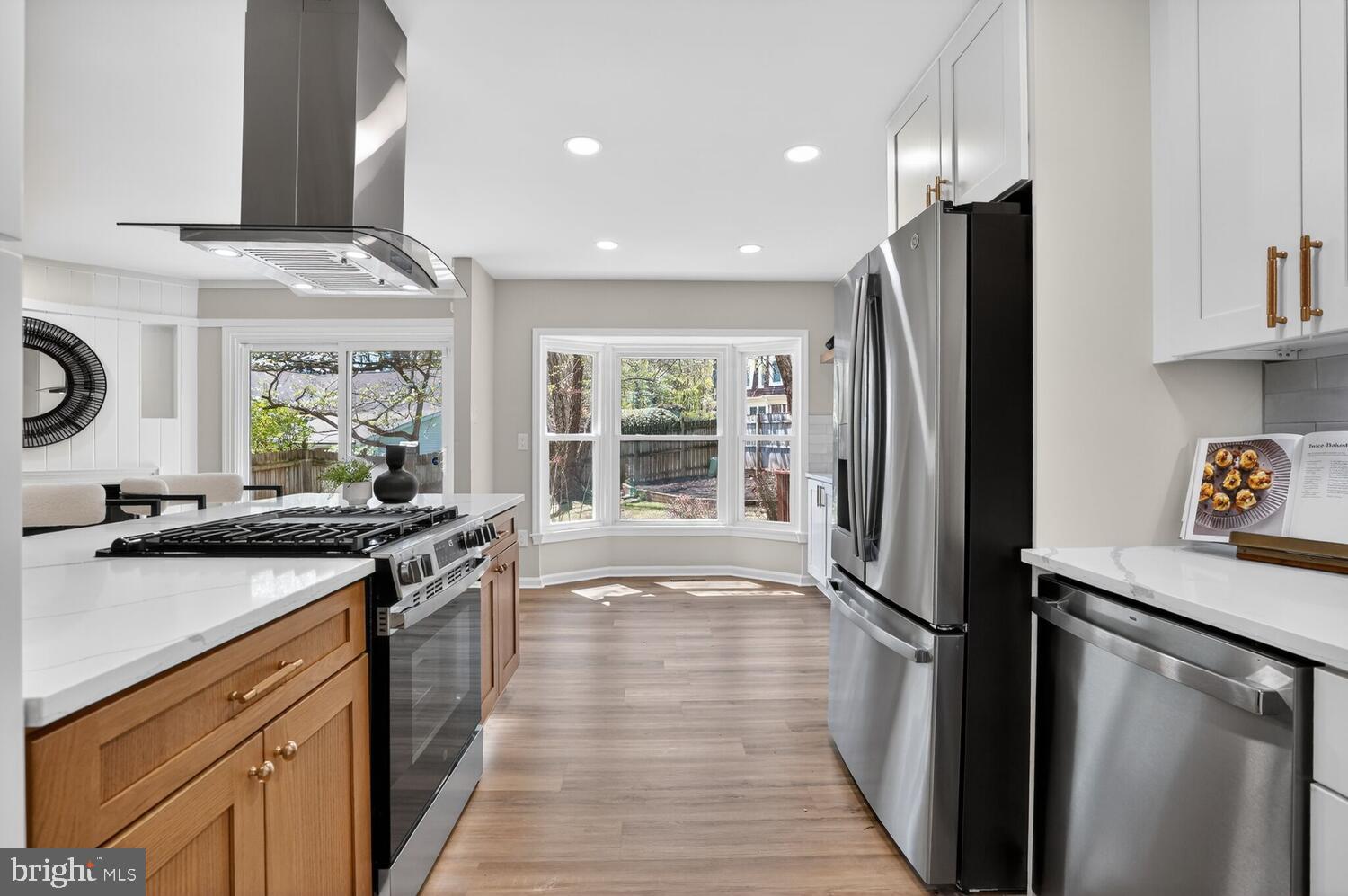 9217 Dorothy Lane Springfield, VA 22153 - Photo 13 of 58 a kitchen with stainless steel appliances granite countertop a refrigerator a sink dishwasher a stove and white countertops with wooden floor