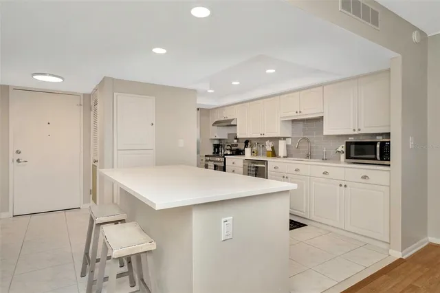 a kitchen with white cabinets stainless steel appliances and sink