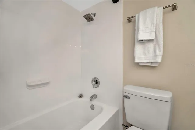 a spacious bedroom with a bed and a chandelier