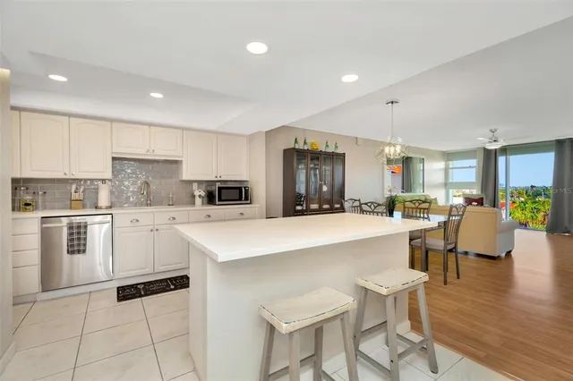 a kitchen with a sink a stove a refrigerator and white cabinets