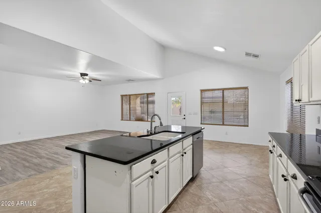 a kitchen with granite countertop a sink and a refrigerator