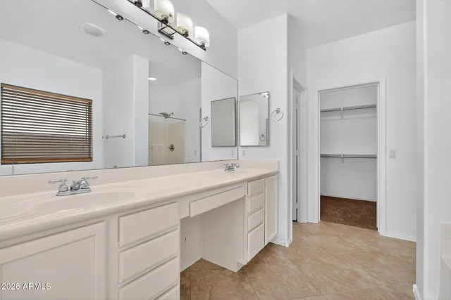 a spacious bathroom with a double vanity sink a mirror and a shower
