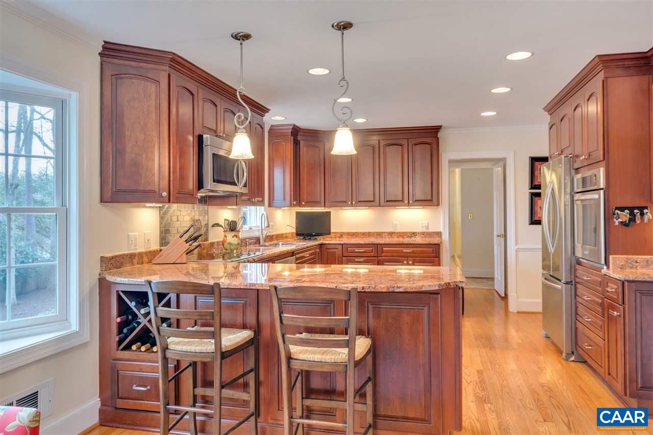 1442 Grove Road Charlottesville, VA 22901 - Photo 5 of 31 a kitchen with kitchen island granite countertop wooden cabinets and a refrigerator