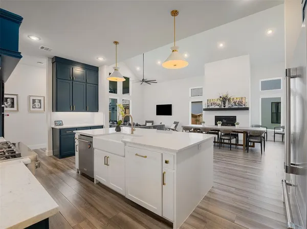a large white kitchen with lots of counter space and chandelier