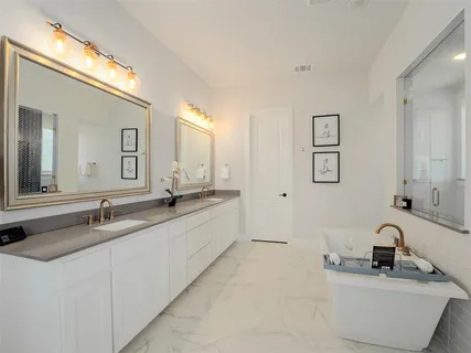 a bathroom with double vanity sinks and a mirror
