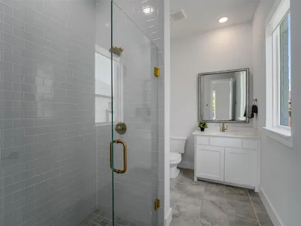 a bathroom with a sink a toilet and shower