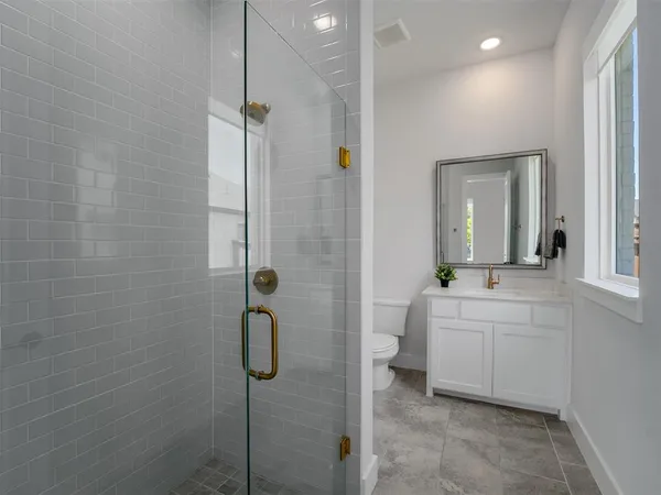 a bathroom with a sink a toilet and shower