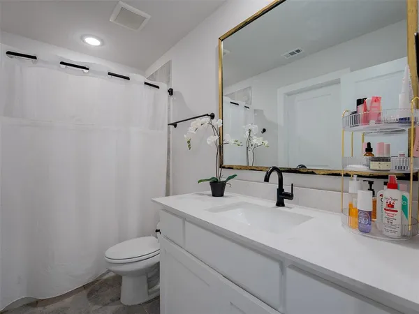 a bathroom with a sink a toilet and shower