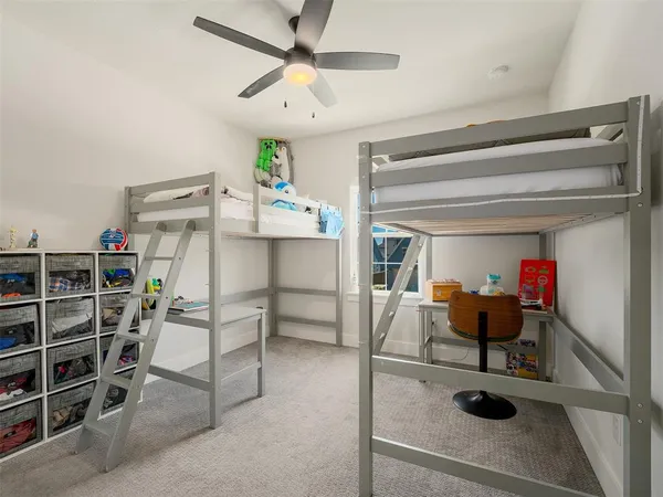 a dining room with furniture and a chandelier fan