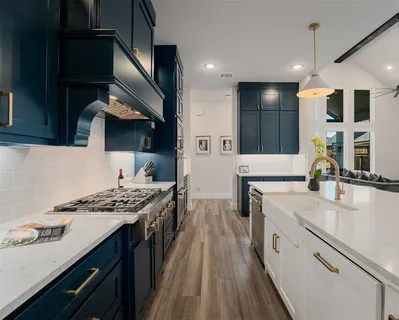 a kitchen with stainless steel appliances granite countertop a sink stove and cabinets