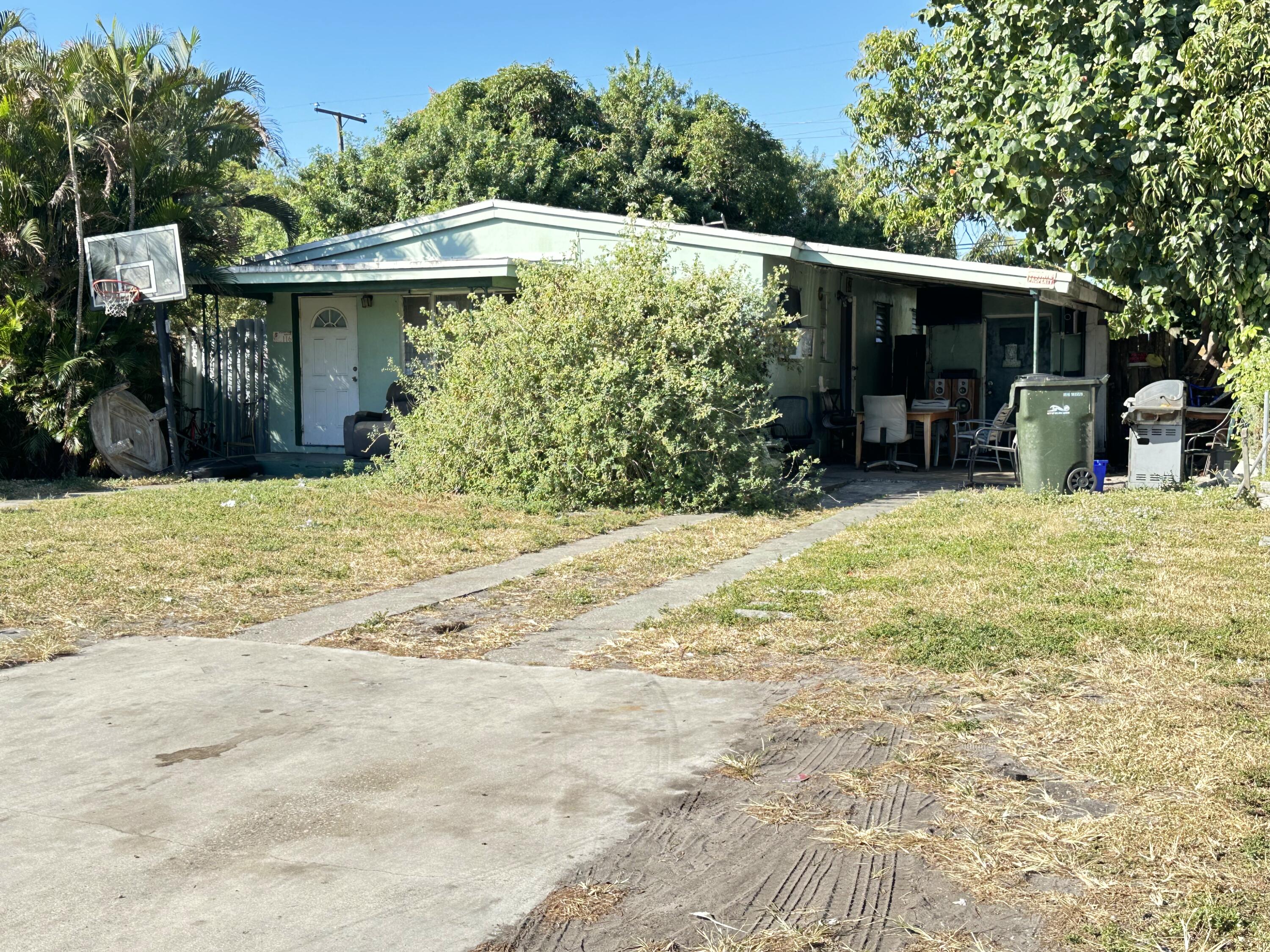116 Southwest 11th Avenue Delray Beach, FL 33444 - Photo 1 of 10 a view of a house with floor to ceiling windows and a yard
