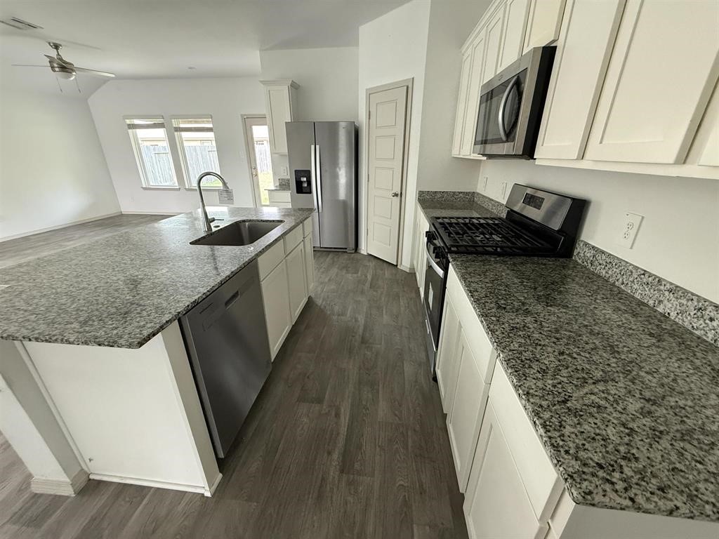 6710 Riplee Street Beaumont, TX 77708 - Photo 6 of 15 a kitchen with granite countertop a sink stove and cabinets