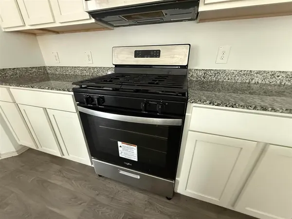 a stove top oven sitting inside of a kitchen