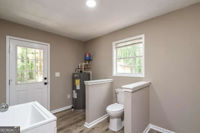 a bathroom with a sink toilet and window