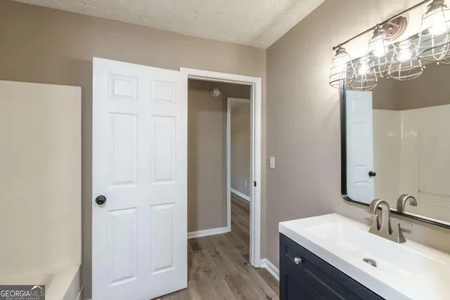 a bathroom with a sink a light fixture and a mirror