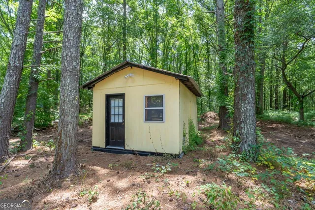a view of a house with backyard and trees