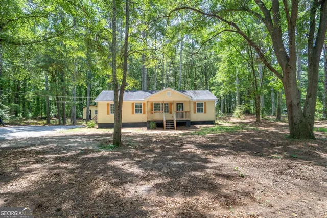 a view of a house with backyard and trees