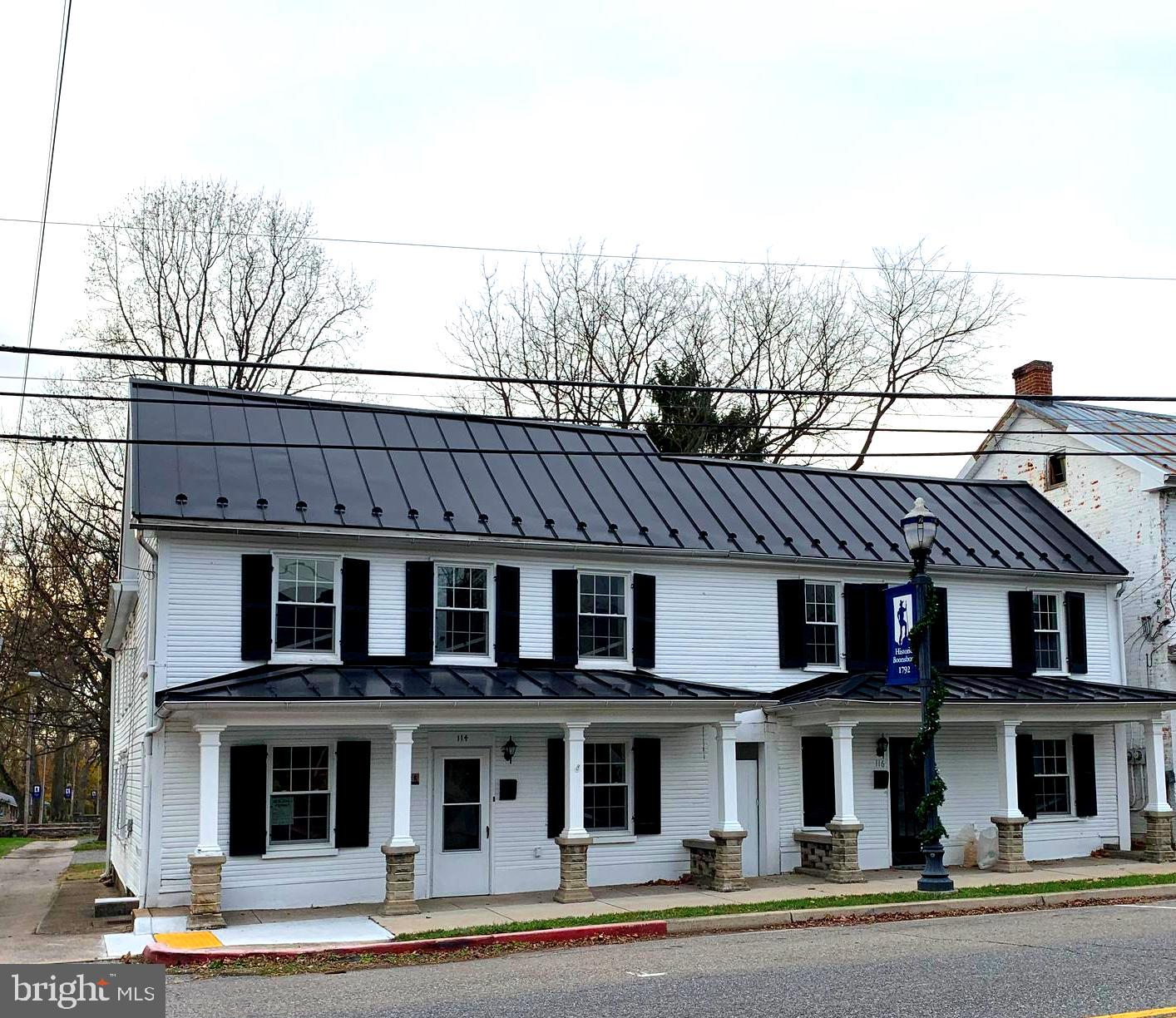 116 North Main Street Boonsboro, MD 21713 - Photo 2 of 44 a view of a brick house with large windows and a table and chairs