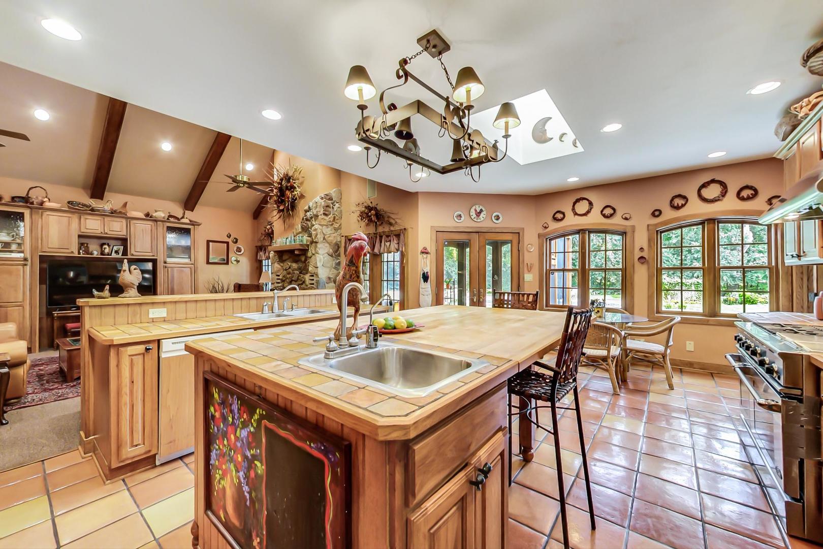 8901 Maple Avenue Burr Ridge, IL 60527 - Photo 12 of 68 a kitchen with a stove a kitchen island a dining table and chairs with wooden floor